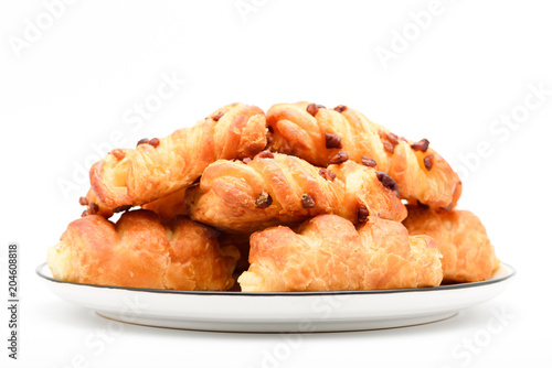 Closeup of mini danish pastries with pecan nuts on top in the plate on white background.
