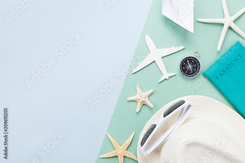 Summer holidays background from travel supplies on pastel paper top view. Flat lay style.