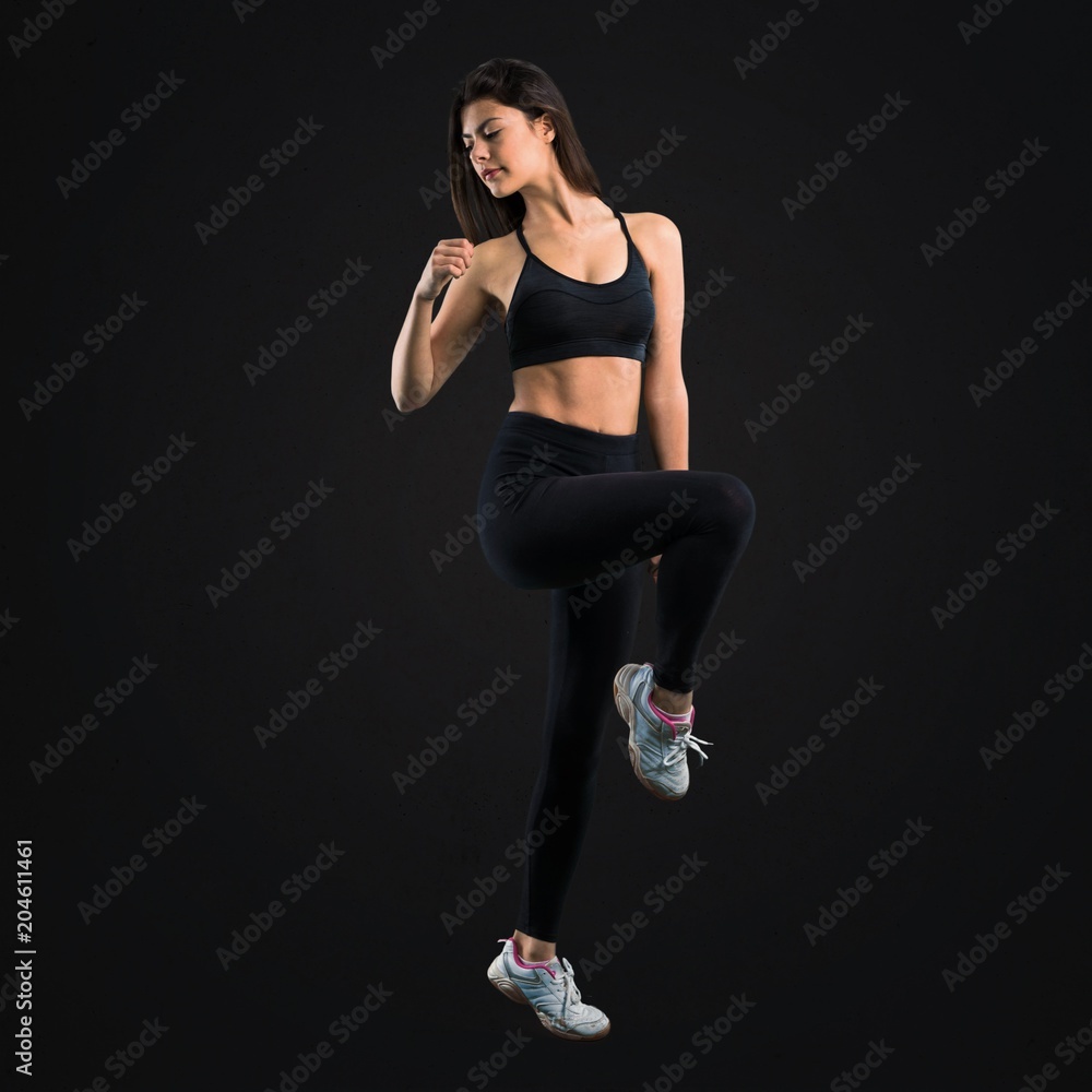 Young sport girl stretching on black background Young sport girl stretching on black background