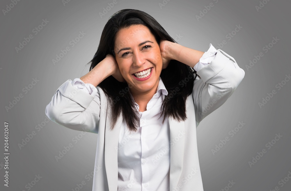 Pretty woman covering her ears on grey background Pretty woman covering her ears on grey background