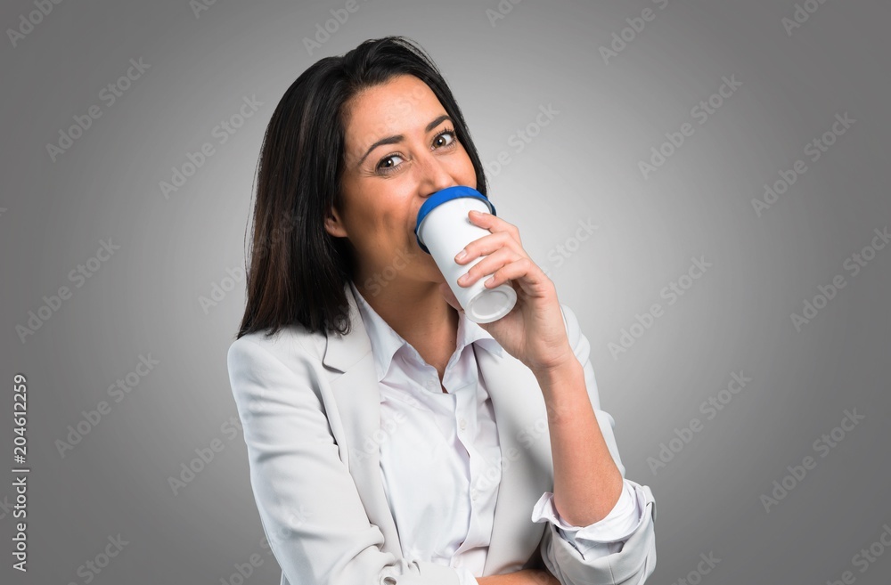 Pretty woman holding coffee to take away on grey background Pretty woman holding coffee to take away on grey background