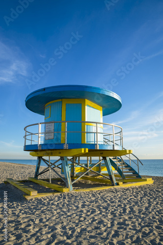 Bright scenic morning view of an iconic, brightly painted, circular lifeguard tower standing empty on South Beach in Miami, Florida © lazyllama