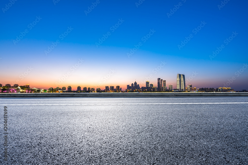 empty asphalt road with city skyline