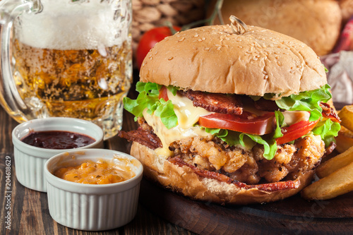 Delicious burger with chicken, bacon, tomato and cheese