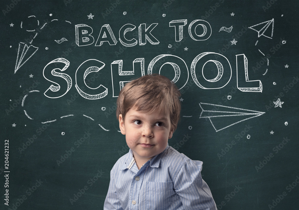 Adorable little boy with blackboard and back to school concept