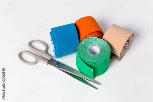 colored kinesio tapes with a pair of scissors photo