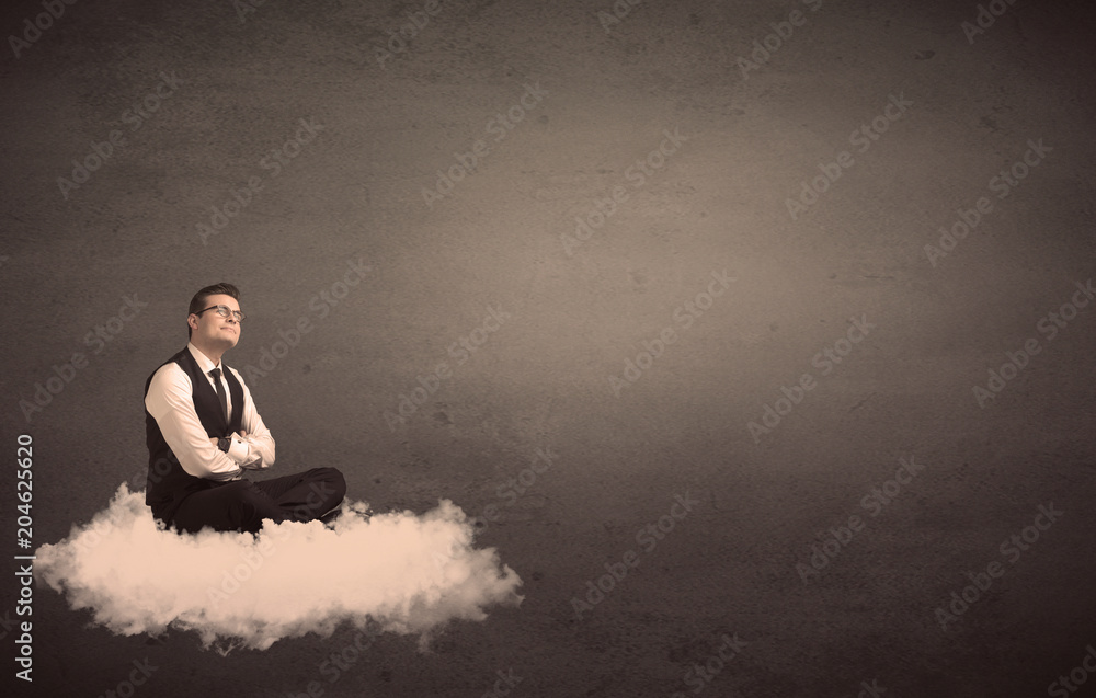 Caucasian businessman sitting on a white fluffy cloud wondering with a plain grunge background