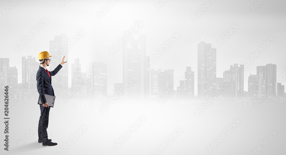 Young supervisor architect standing and looking at a big city panorama
Young supervisor architect standing and looking at a big city panorama
