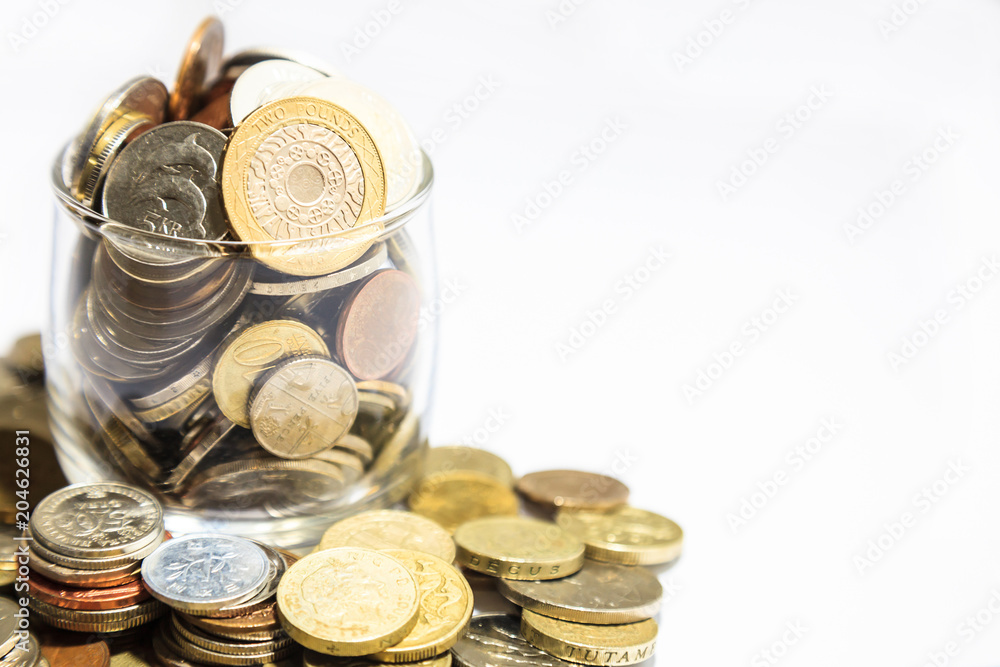 jar of money, various currency coins overflowing on white background jar of money, various currency coins overflowing on white background