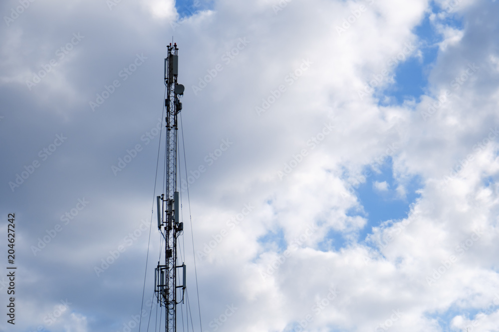 Mobile phone cellular tower silhouette with blue sky.