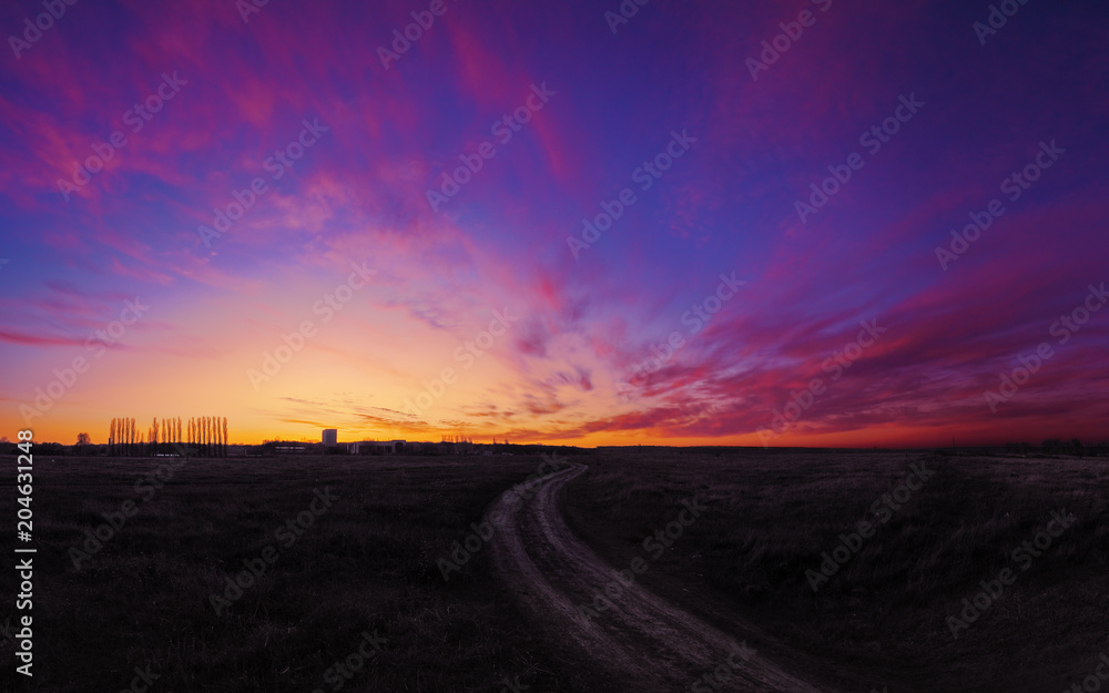 Sunset over the field colorfull with road to future