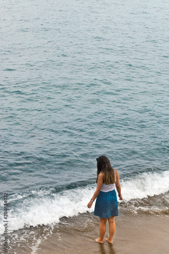 Girl walking into sea Italy