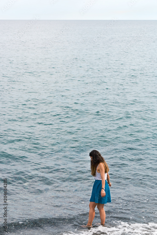Girl walking into sea Italy