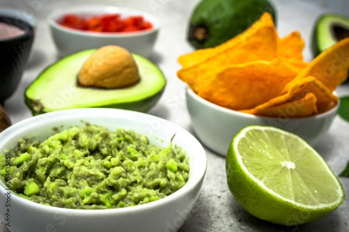 Traditional mexican food - guacamole with avocado and tortilla chips on table, party food for sharing