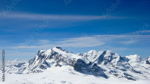 panorama mountain landscape in the Swiss Alps near Zermatt on a beautiful day in late winter under a blue sky