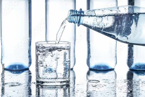 Mineralwasser in ein Glas eingeschenkt, Hintergrund weiß