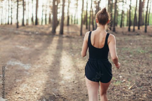 healthy lifestyle brunet fitness sporty woman runner running in pine morning forest © Andrii