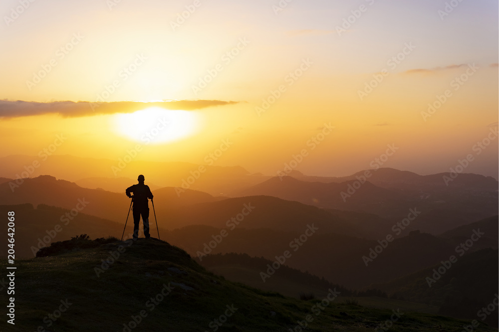 Man on top of mountain at sunset. Conceptual scene.