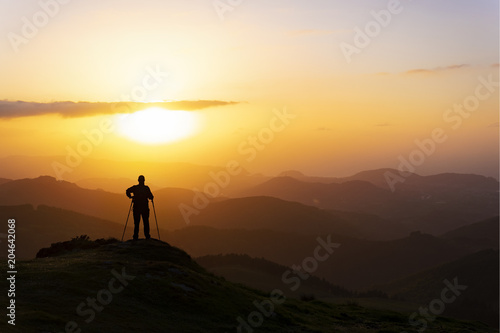 Man on top of mountain at sunset. Conceptual scene.