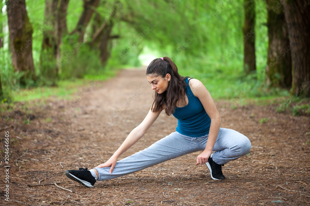 Beautifull sports girl in the park is engaged in fitness, warm-up Beautifull sports girl in the park is engaged in fitness, warm-up