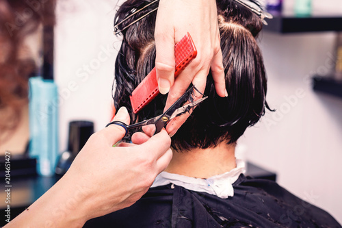 Woman in beauty salon.  Pofessional hairdresser makes a hairstyle_ photo