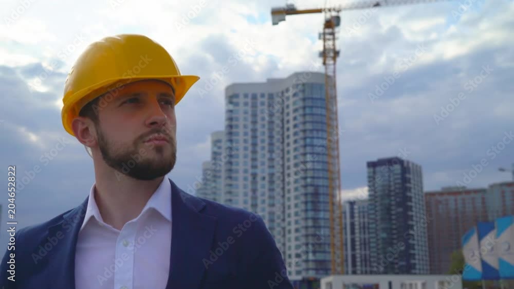 young man builder smiling on building background. Close-up portrait of a man. a man is happy for the work done. 4k young man builder smiling on building background. Close-up portrait of a man. a man is happy for the work done. 4k