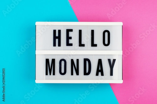 Hello Monday - text on a display lightbox on blue and pink bright background. photo