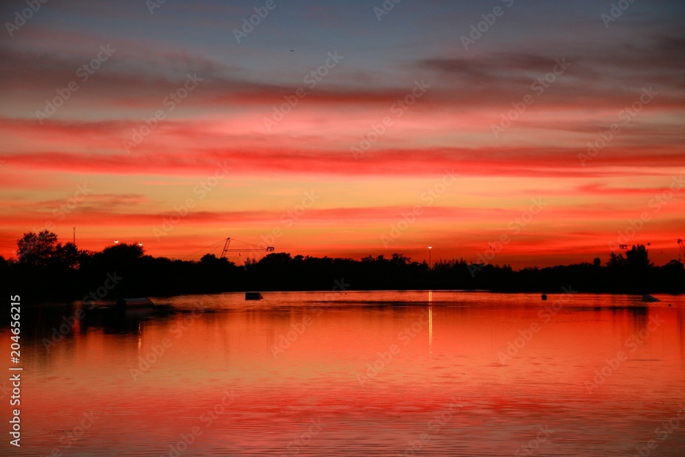 After Sunset on the Ski Rixen Lake with Reddish Orange Clouds at Quiet Waters Park, Deerfield Beach, Florida After Sunset on the Ski Rixen Lake with Reddish Orange Clouds at Quiet Waters Park, Deerfield Beach, Florida