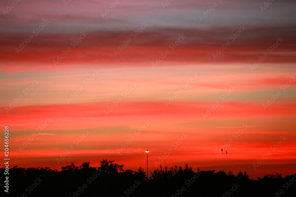 After Sunset on the Ski Rixen Lake with Reddish Orange Clouds and One Light at Quiet Waters Park, Deerfield Beach, Florida After Sunset on the Ski Rixen Lake with Reddish Orange Clouds and One Light at Quiet Waters Park, Deerfield Beach, Florida