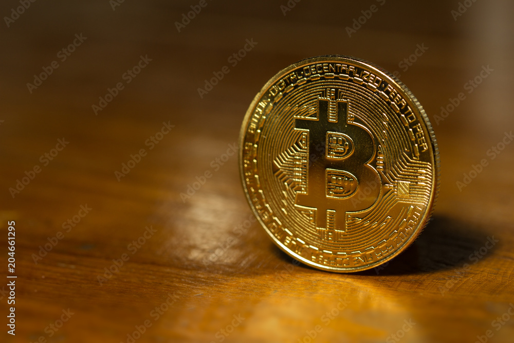 Golden Bitcoin stand alone on wooden table. Bitcoin is a major currency. of cryptocurrency. Golden Bitcoin stand alone on wooden table. Bitcoin is a major currency. of cryptocurrency.