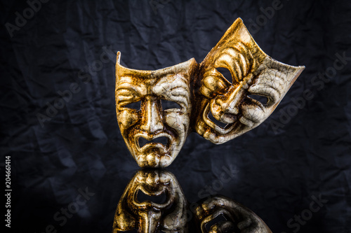 two theatrical masks are good and evil on a black background