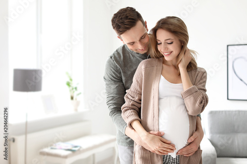 Fotografie, Obraz Young pregnant woman with her husband at home