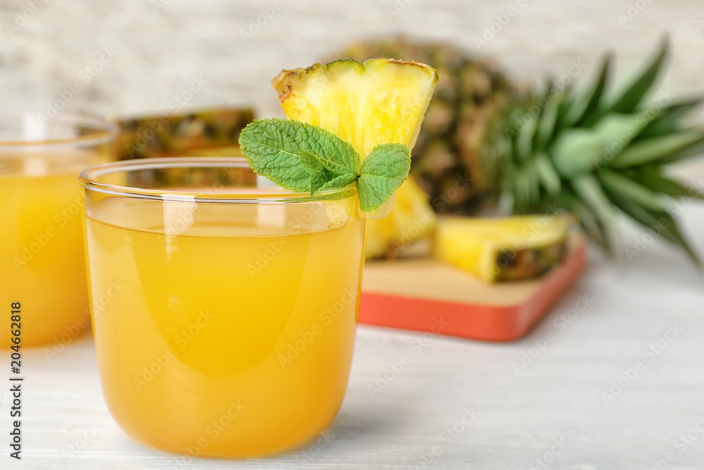 Fototapeta premium Glass with delicious pineapple juice on table
