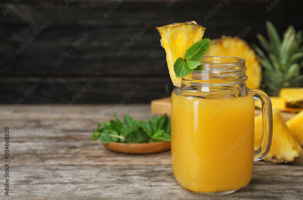 Mason jar with delicious pineapple juice on table Mason jar with delicious pineapple juice on table