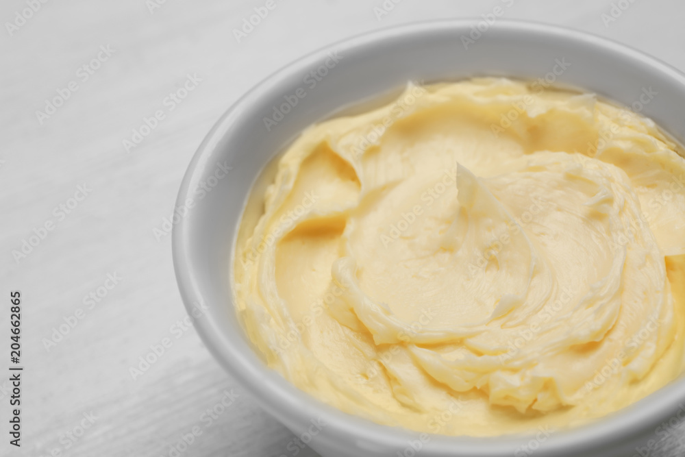 Bowl with tasty fresh butter on table, closeup Bowl with tasty fresh butter on table, closeup