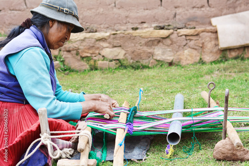 Native american woman weaving typical aymara clothing.