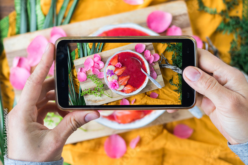 Woman hands take phone photography of food dessert. Smartphone photo of lunch, dinner, food for social media, blogging or instagram. Raw vegan vegetarian healthy food