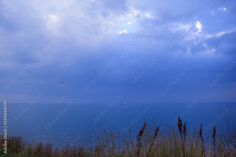 view of the evening sea and tiny ships view of the evening sea and tiny ships
