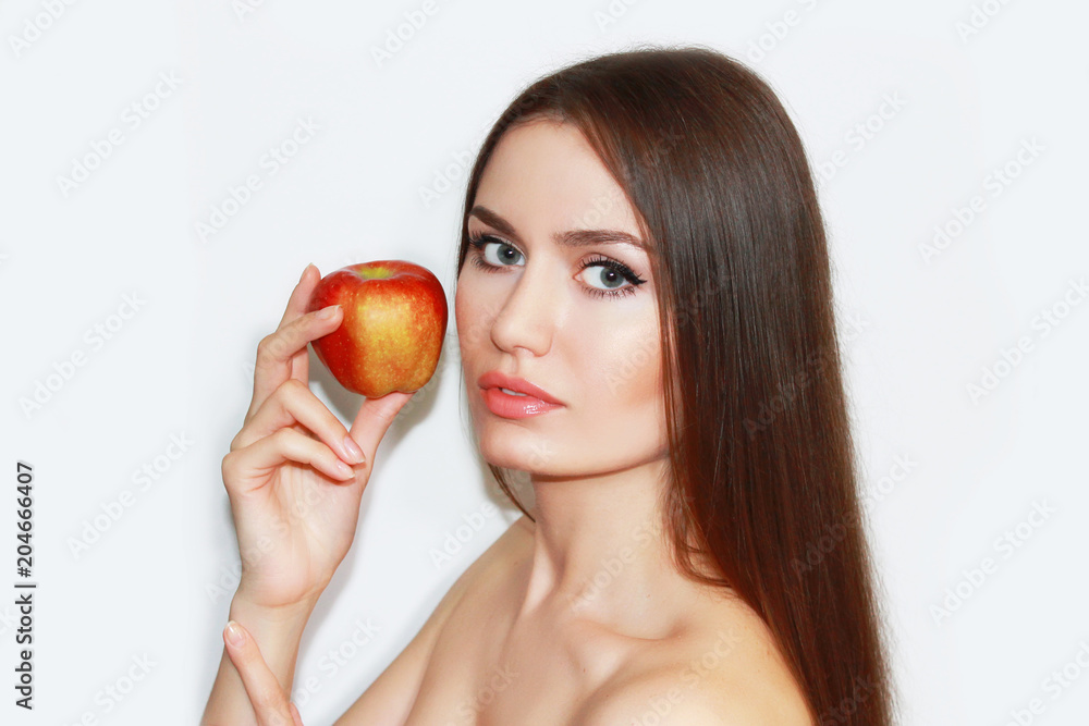 Natural brunette woman girl with an apple on a white background Natural brunette woman girl with an apple on a white background