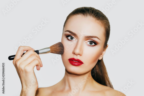 beautiful woman with beautiful make-up. Woman with a brush for make-up . Make-up artist