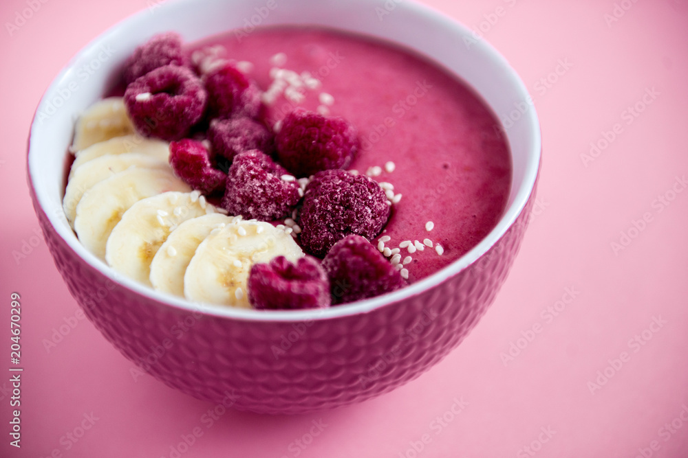 smoothie bowl frozen raspberry and banana, healthy nutrition, pink background smoothie bowl frozen raspberry and banana, healthy nutrition, pink background