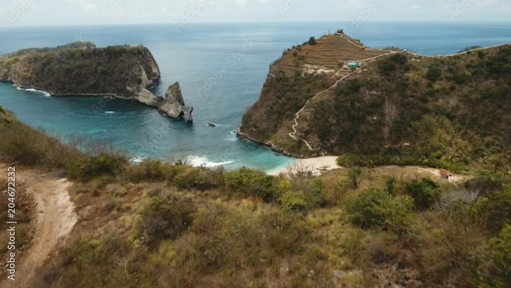 Aerial view of beautiful white sand Atuh beach among rocks for relax. Clear blue ocean waves rolling to the beach. Nusa Penida, Bali, Indonesia. Travel concept. Aerial footage. Aerial view of beautiful white sand Atuh beach among rocks for relax. Clear blue ocean waves rolling to the beach. Nusa Penida, Bali, Indonesia. Travel concept. Aerial footage.