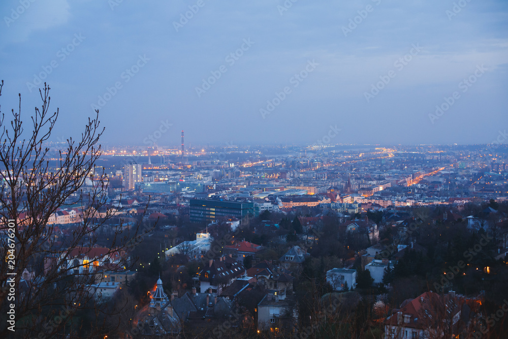 Obraz premium Beautuful super-wide angle aerial night view of Budapest, Hungary, with Danube river, Parliament building and scenery beyond the city, seen from observation point of Gellert Hill
