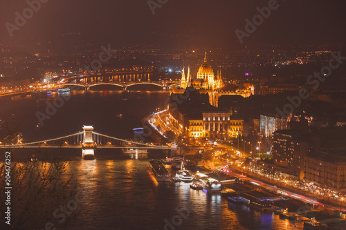 Beautuful super-wide angle aerial night view of Budapest, Hungary, with Danube river, Parliament building and scenery beyond the city, seen from observation point of Gellert Hill
