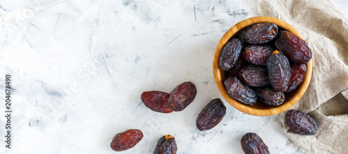 Delicious dates in a wooden bowl.