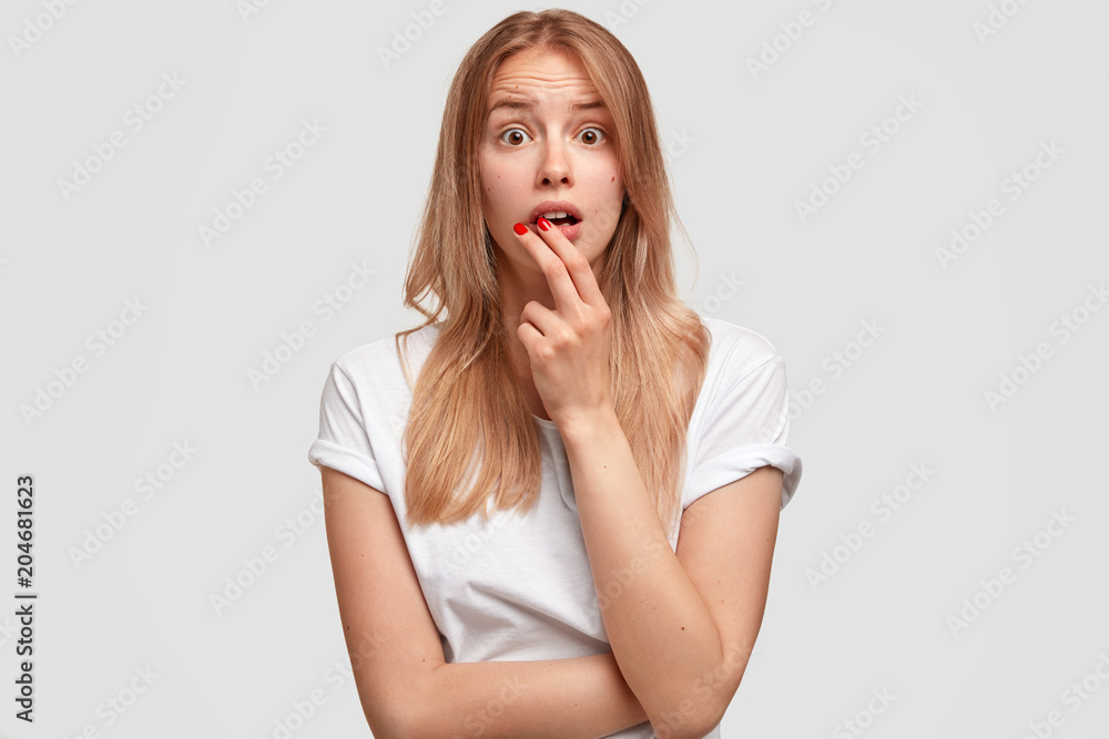 Pleasant looking shocked female looks with frustration and surprised expression, wears casual clothes, stands indoor. Amazed young Caucasian woman has appealing appearance, expresses anxiety Pleasant looking shocked female looks with frustration and surprised expression, wears casual clothes, stands indoor. Amazed young Caucasian woman has appealing appearance, expresses anxiety