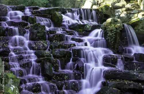 The ornamental Cascade waterfall with purple water in Virginia Water, Surrey, UK