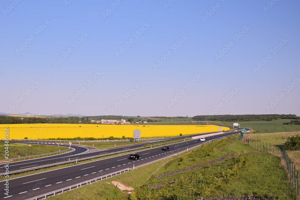 Evening spring czech landscape near highway D7  leading from Chomutov city to Prague city between flowering fields
