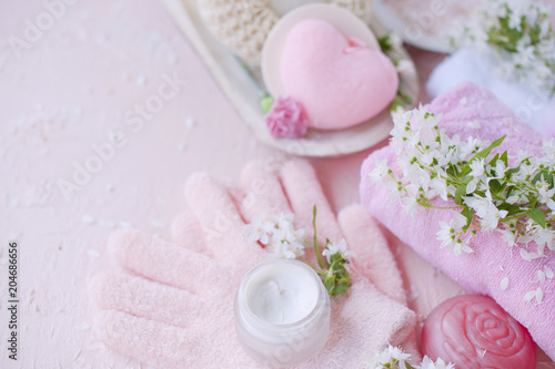 spa hand care  sea salt  cream and gloves. The flowers are white. Pink background. Place for text