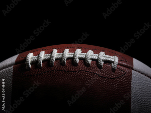 Closeup of an American Football Game Ball Against a Black Background